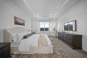Bedroom featuring carpet floors, a raised ceiling, and recessed lighting