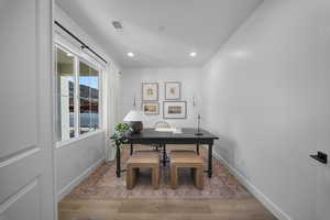 Office with wood finished floors and recessed lighting