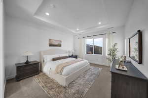 Bedroom featuring carpet flooring, recessed lighting, and a raised ceiling