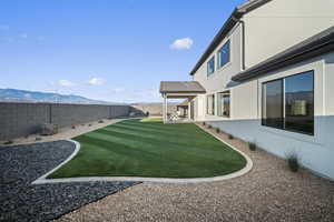 Fenced backyard featuring a mountain view and a patio area