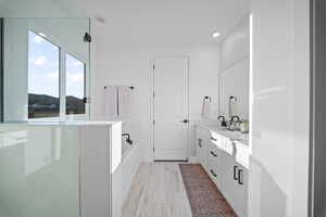 Bathroom with double vanity, a bath, a shower stall, and recessed lighting