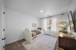Bedroom featuring dark colored carpet and baseboards