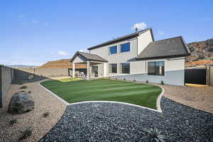 Back of house with a patio area, a fenced backyard, and a mountain view