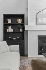 Detailed view of a glass covered fireplace and wood finished floors