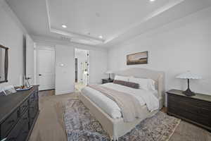 Bedroom with carpet, recessed lighting, ensuite bathroom, and a raised ceiling