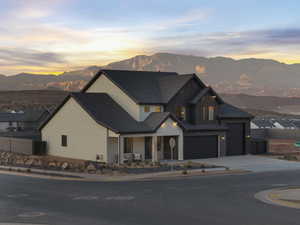 Modern farmhouse style home featuring a mountain view, covered porch, concrete driveway, board and batten siding, and an attached garage