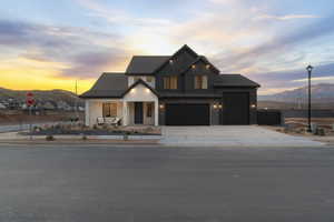 Modern farmhouse style home featuring a mountain view, covered porch, driveway, and board and batten siding