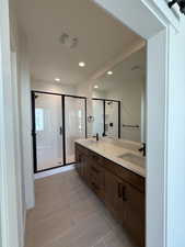 Full bath with double vanity, a stall shower, and recessed lighting