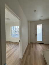 Hallway with light wood-style flooring and a textured ceiling