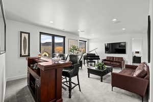 Upper level family room area with light colored carpet and recessed lighting