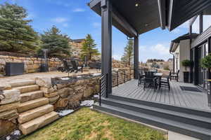 Wooden terrace with outdoor dining space and a patio