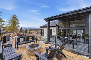 View of patio featuring a mountain view and an outdoor living space with a fire pit