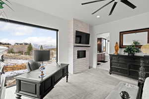 Primary suite with a ceiling fan, light carpet, a fireplace, and recessed lighting