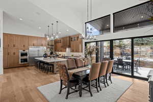 Dining area featuring light wood-type flooring, lofted ceiling, and hanging lights