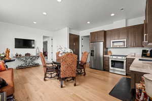 Dining room with light wood-style flooring and recessed lighting