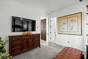 Bedroom with light colored carpet and baseboards
