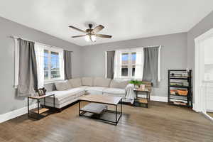 Living room with ceiling fan, wood finished floors, and healthy amount of natural light