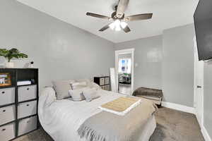 Carpeted bedroom with baseboards and ceiling fan