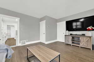 Living area with dark wood-style flooring and baseboards