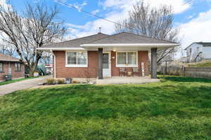 Bungalow-style house with covered porch, brick siding, and roof with shingles