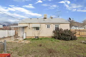 Back of house featuring a fenced backyard, a shingled roof, and a gate