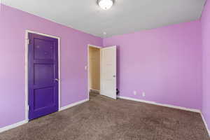 Unfurnished bedroom featuring carpet and baseboards