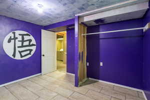 Unfurnished bedroom featuring washer / dryer and baseboards