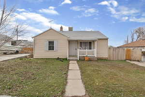 Bungalow featuring covered porch and a chimney