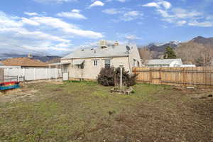 Back of house featuring a mountain view and a fenced backyard
