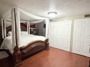 Bedroom featuring a textured ceiling and dark wood-type flooring