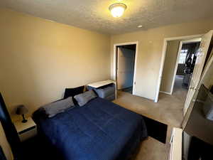 Bedroom with a textured ceiling and carpet