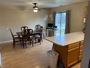 Dining space featuring light wood finished floors, a ceiling fan, and a textured ceiling