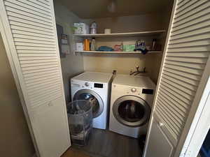 Laundry area with electric panel, washer and dryer, and dark wood-style floors