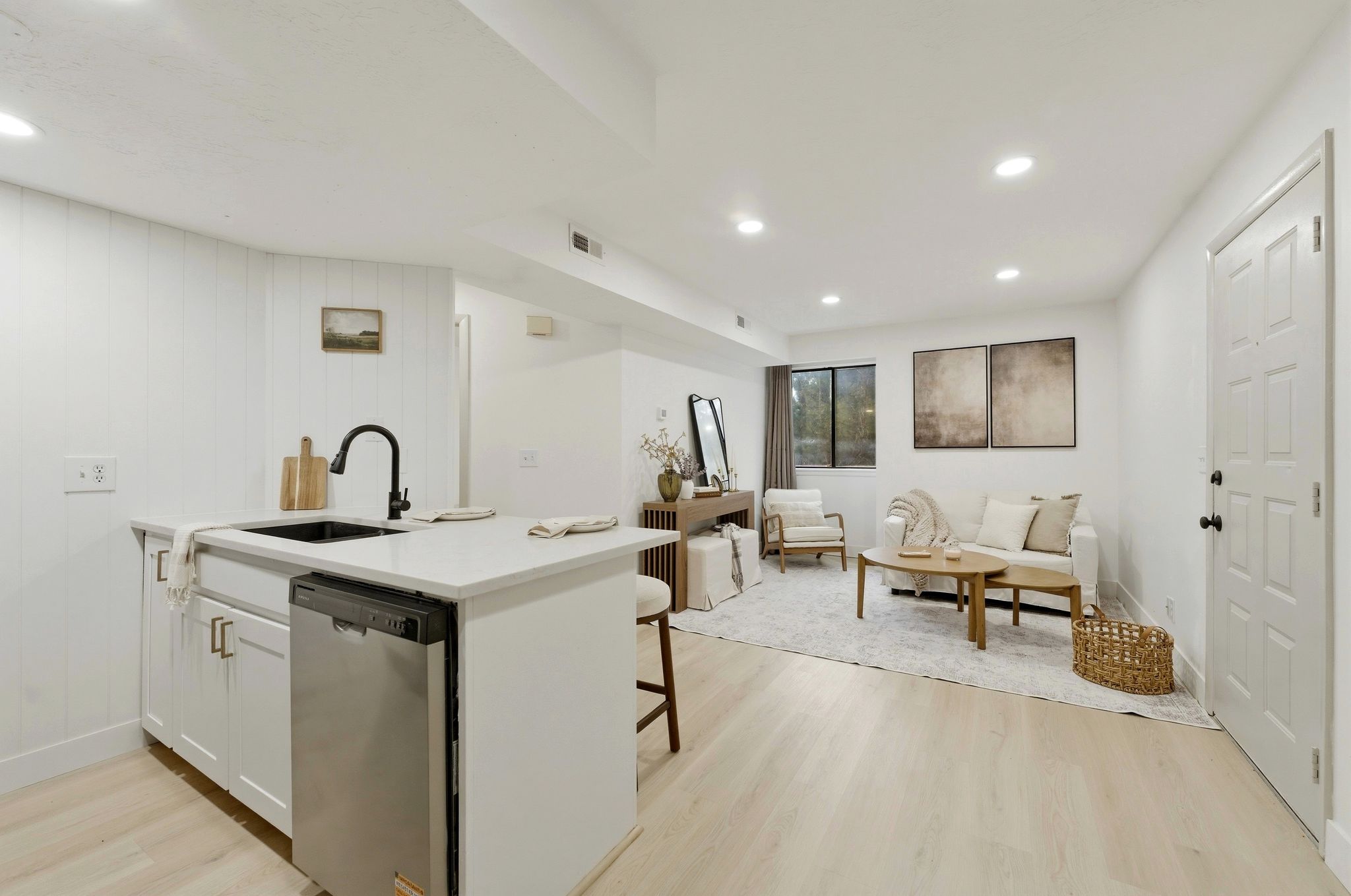 Kitchen with a peninsula, stainless steel dishwasher, open floor plan, white cabinets, and recessed lighting