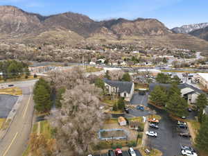 Aerial view of property and surrounding area with a mountainous background and nearby suburban area