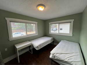 Bedroom featuring dark wood finished floors and a textured ceiling