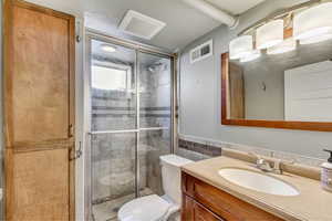 Full bathroom featuring a shower stall, vanity, and tile walls