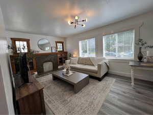 Living room featuring wood finished floors, a brick fireplace, and healthy amount of natural light