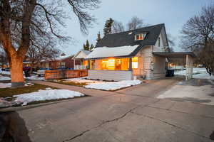 View of front of house featuring an attached carport, concrete driveway, and a shingled roof
