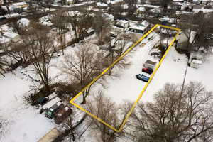 Snowy aerial view featuring property parcel outlined