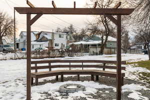 Snow covered deck featuring a residential view and a fire pit