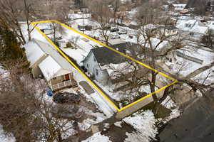 Snowy aerial view featuring a residential view and property parcel outlined