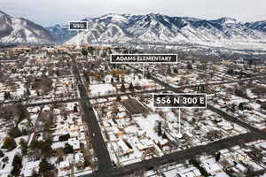 Snowy aerial view featuring a mountain view and a residential view
