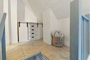 Interior space featuring lofted ceiling and tile patterned flooring