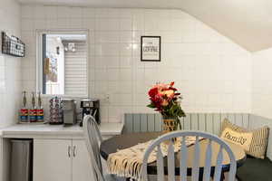 Dining area featuring tile walls and radiator heating unit