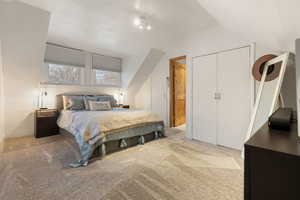 Bedroom featuring carpet flooring, lofted ceiling, and a closet