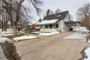 Bungalow featuring a carport, driveway, and a shingled roof