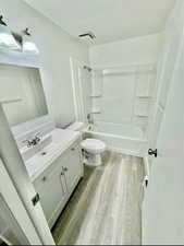 Bathroom with vanity, tub / shower combination, and light wood-type flooring
