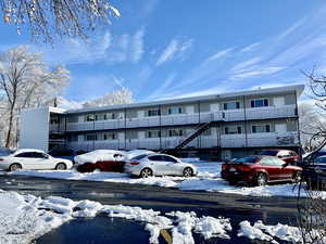 Snow covered building featuring a view of apartment building / complex