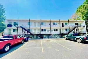 View of apartment building / complex featuring stairway and uncovered parking